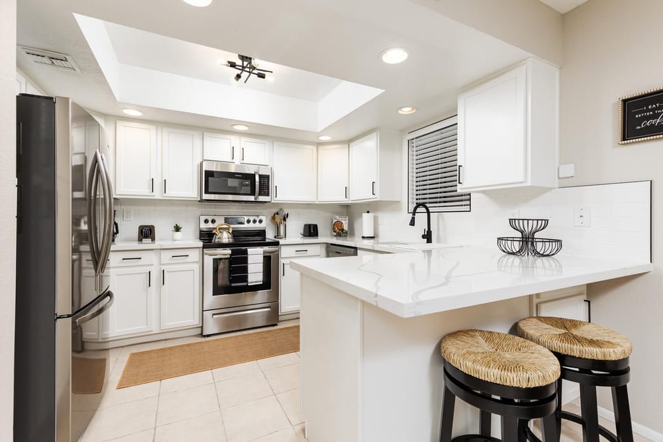 Modern kitchen with sleek appliances and cozy breakfast bar seating