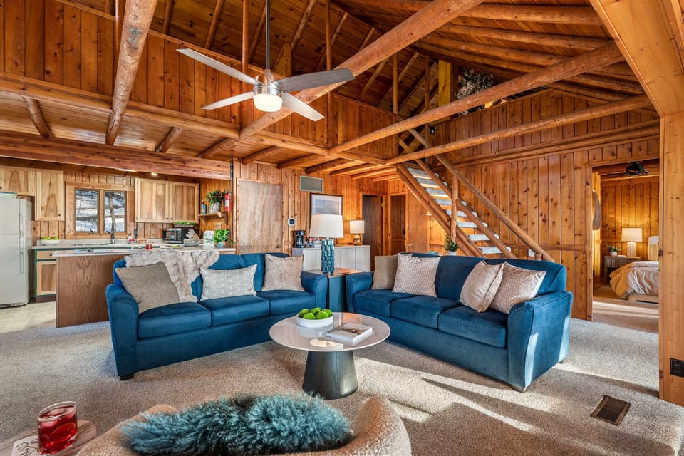 Settle in for a cozy night by the fireplace, surrounded by vaulted ceilings and rich wood beams that bring comfort, warmth, and a true Up North feel.