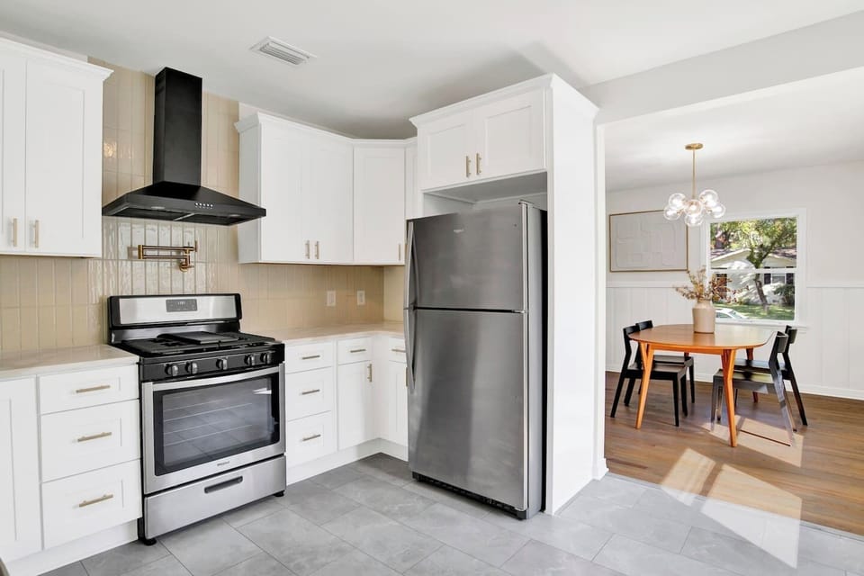 Fully equipped kitchen with stainless steel appliances, coffee bar, and dining space for family meals or work breaks.