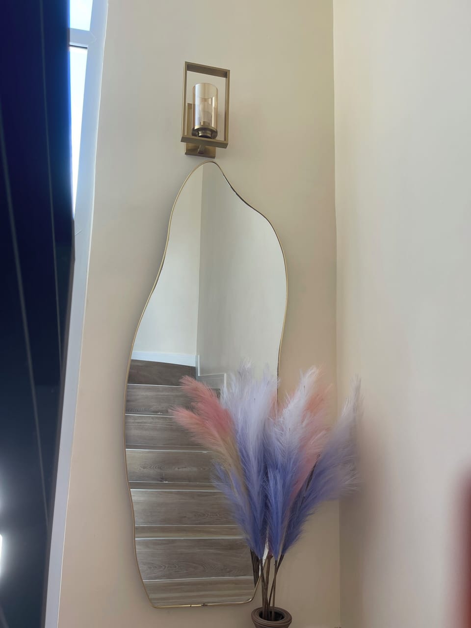 Stunning staircase wall with accent shape mirror that gives a flair & cozy charm