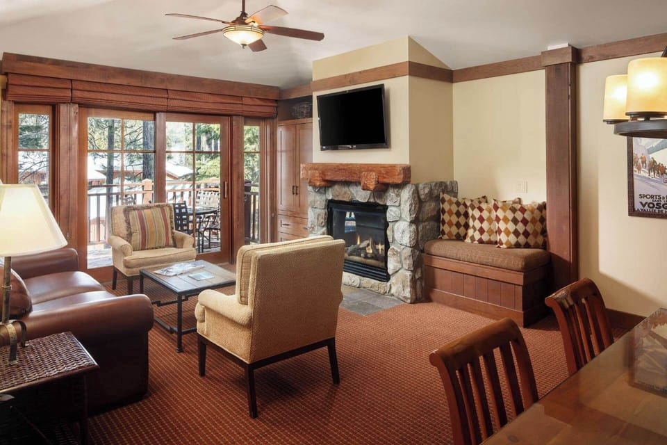 Spacious living room features a sleeper sofa for two, TV, fireplace, and door to the patio/balcony (view varies-assigned at check-in)