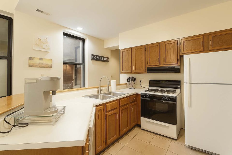 Kitchen with gas range, full-size fridge, and dedicated coffee bar.