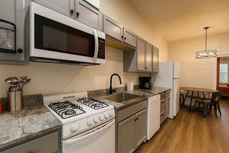 Kitchen with gas range, granite counters, microwave, and dishwasher.