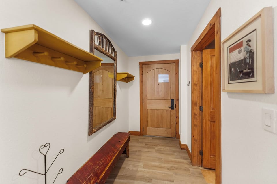 Step into your cozy mountain retreat through this charming entryway with handcrafted wood details and rustic touches.