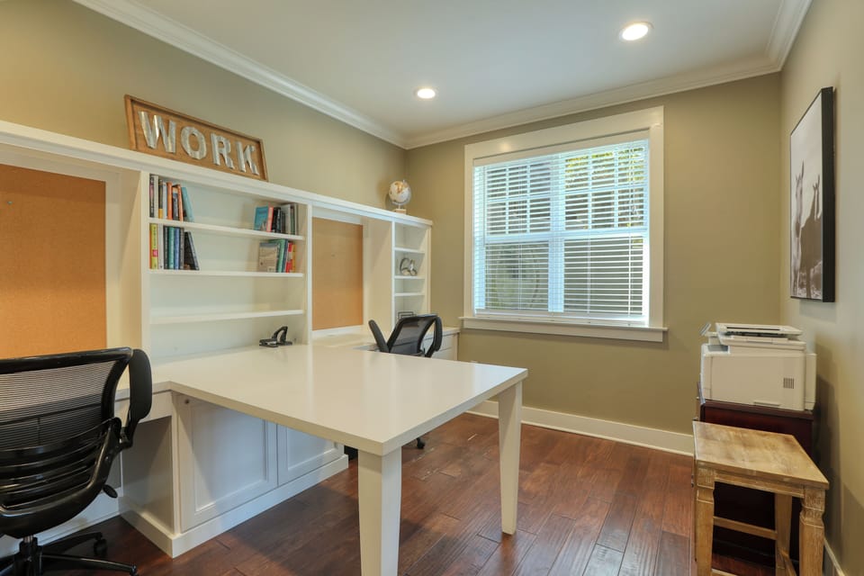 A convenient, built-in home office located across the formal living room (off the foyer). Featuring a two-person desk and an accessible printer—perfect for remote work or printing essentials.