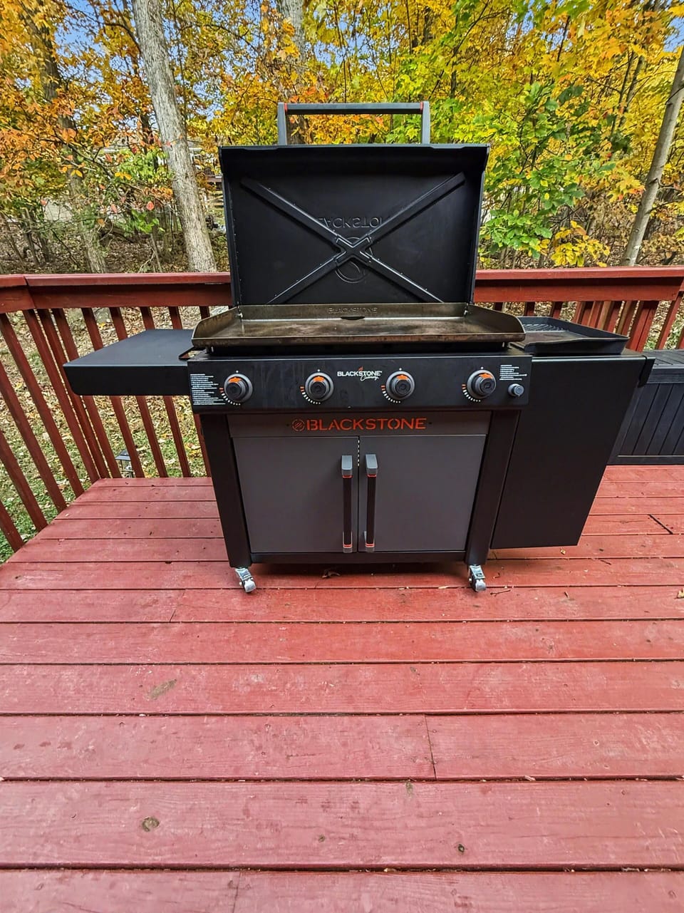 Spacious deck with seating, Blackstone grill, and wooded views