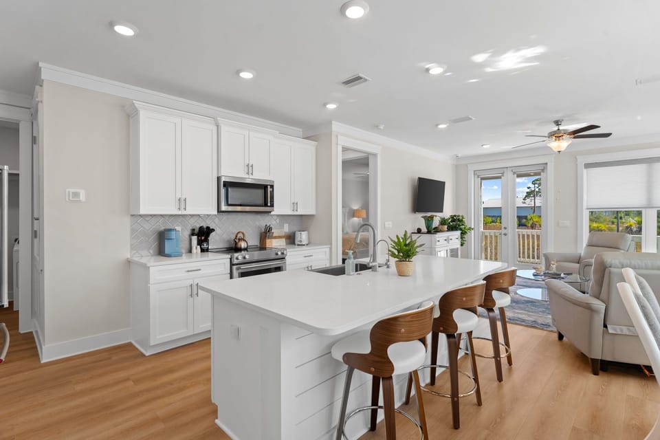 Your modern kitchen flows seamlessly into the living area, perfect for cooking while enjoying conversation and natural light streaming through the windows.