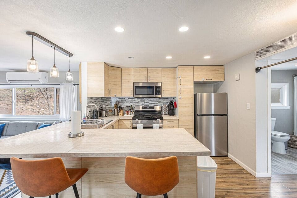 Cook, sip, and chat! This open kitchen and counter setup makes mealtime a breeze.