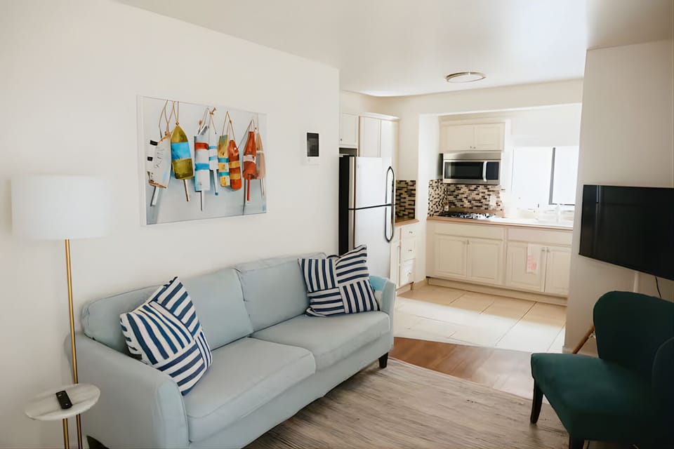 Cozy living area with soft blue sofa and beach-themed artwork.