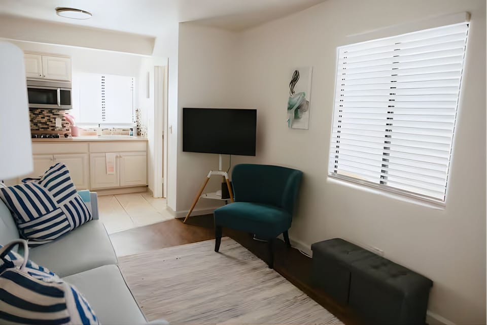 Relaxing lounge area with TV and stylish teal accent chair.