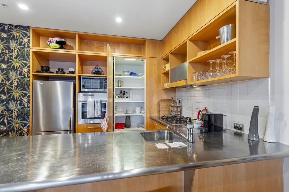 The kitchen properly open for business — pantry door ajar, the full range of crockery, glassware, and appliances on show. Everything you`d want, right where you`d expect it