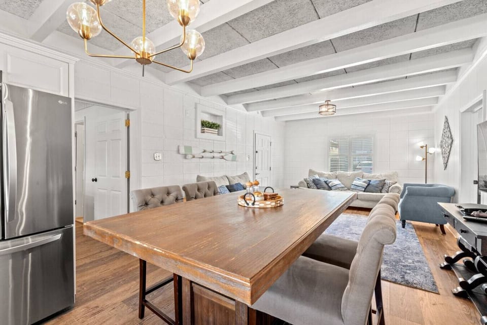 Modern raised dining table with plush upholstered chairs, featuring a sleek block-style design. The soft seating and contemporary décor create a stylish, comfortable space perfect for meals or gathering together.