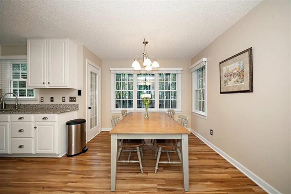 Bright dining area with large windows and open kitchen layout