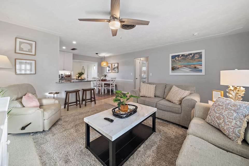 The living room space seamlessly blends with seating at the bar and dining room area.