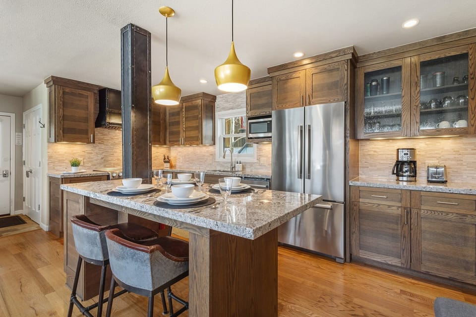 Spacious kitchen with stainless steel appliances, large kitchen island with seating for four.