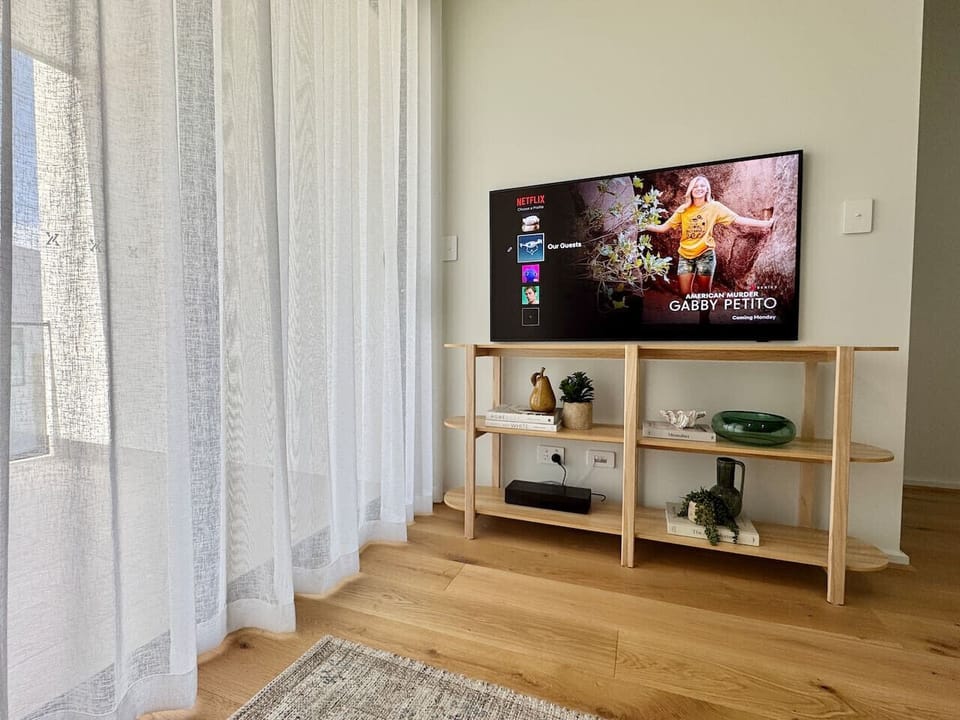 Upstairs Living Area – Light & Bright Light-filled living area featuring a Samsung 55-inch Smart TV with Netflix and Disney+. Slide open the doors to the north-facing balcony and enjoy fresh sea air and natural light. 🌊🛋💛