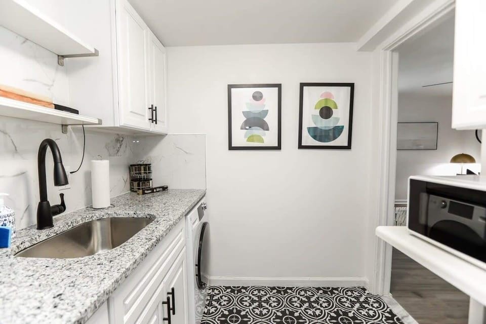 Kitchen with sink, microwave, and additional storage. 
