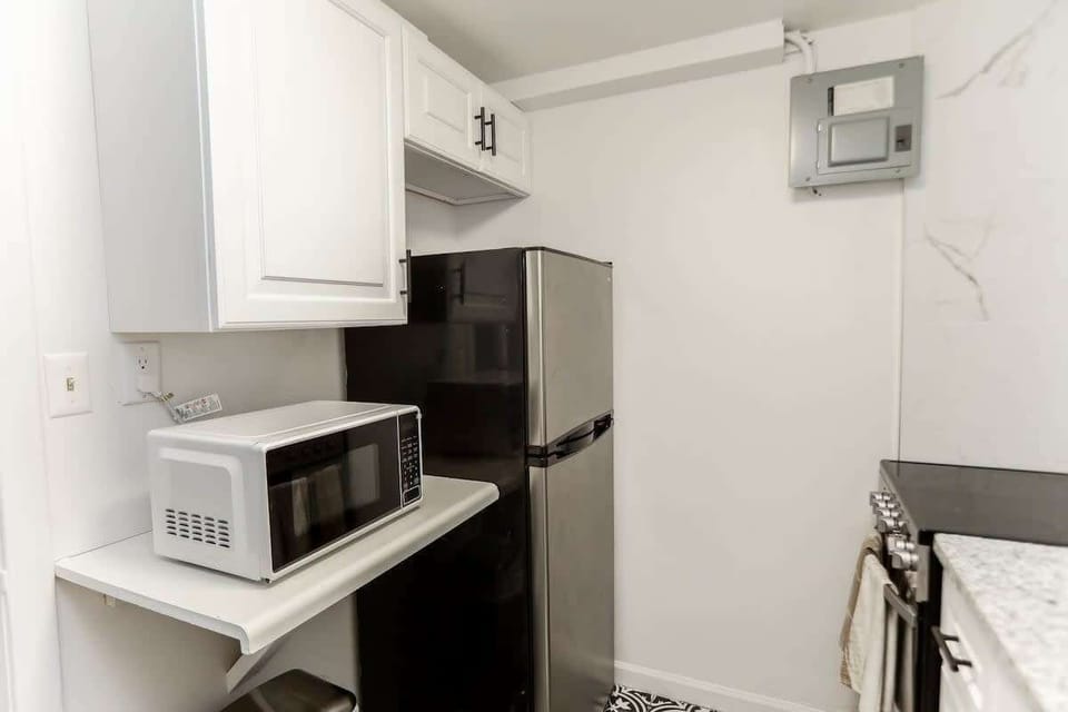 Kitchen with microwave, full fridge, and oven. 