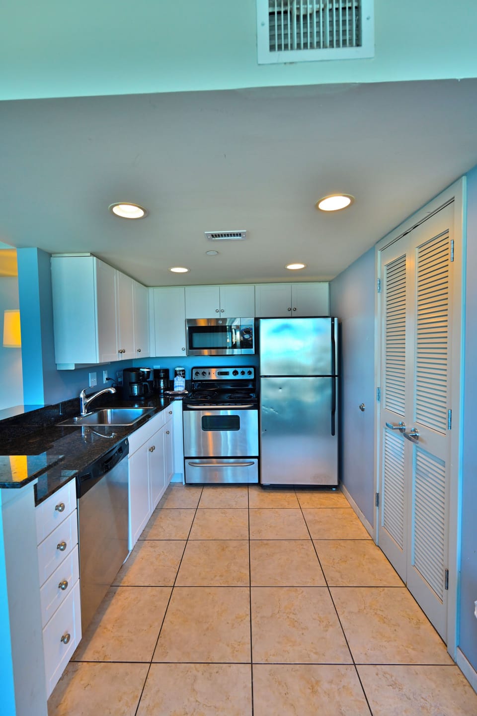 Modern kitchen with stainless appliances and tiled floor
