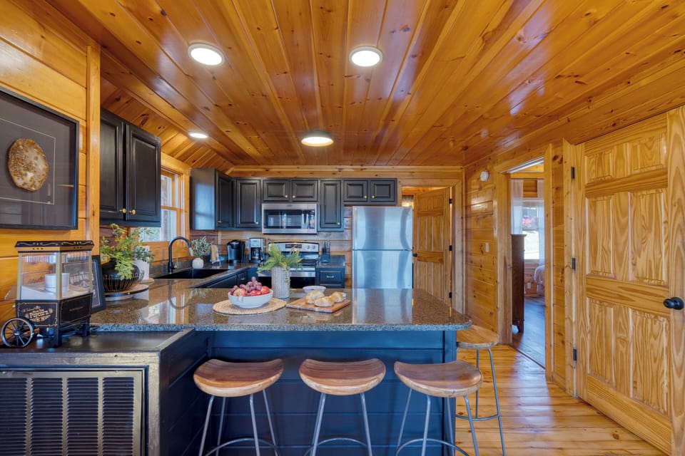 Fully equipped kitchen with granite counters, stainless steel appliances, and bar seating for easy vacation cooking.