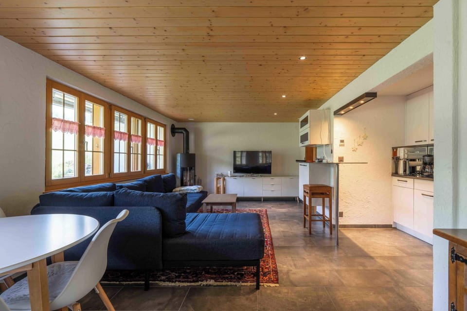 Open-plan living room with sofa, TV and kitchen
