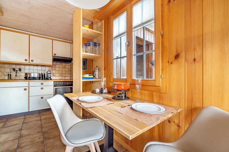 Dining area with wooden table and chairs, perfect for shared meals or planning your next mountain adventure.