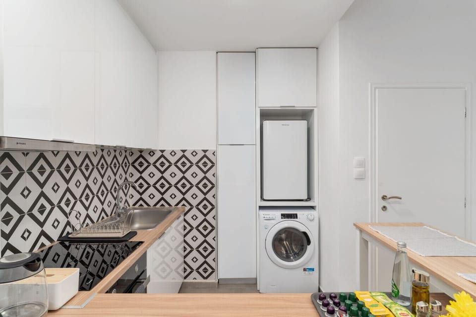 Fully equipped kitchen with oven, fridge, washing machine, and handcrafted tile finishes.