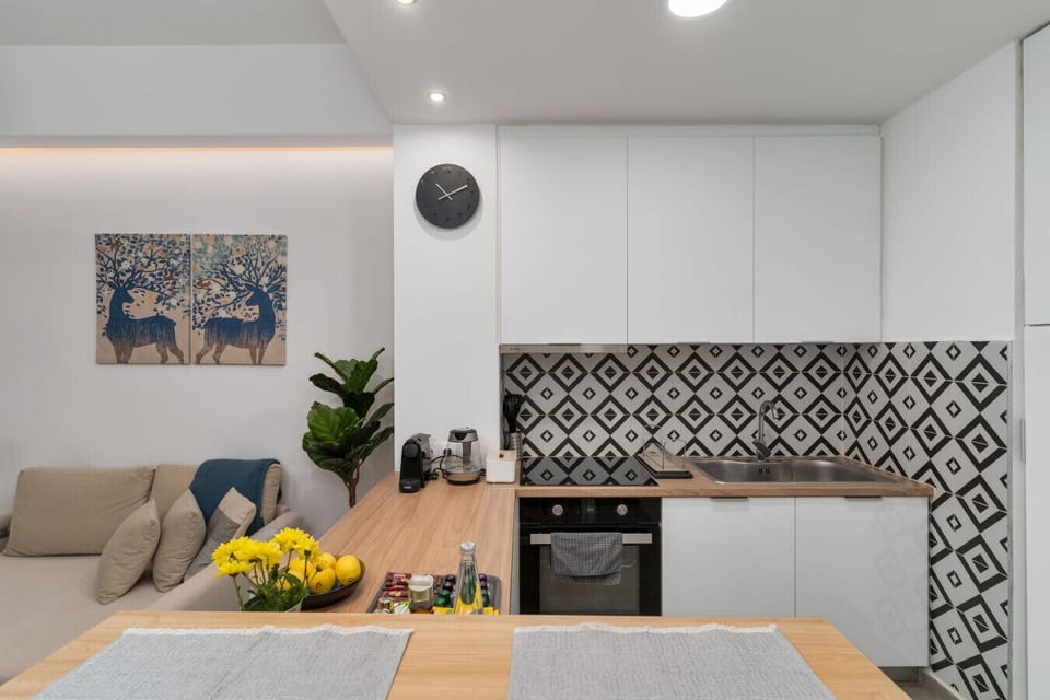 Contemporary kitchen with patterned backsplash, sleek cabinetry, and a welcoming breakfast bar.