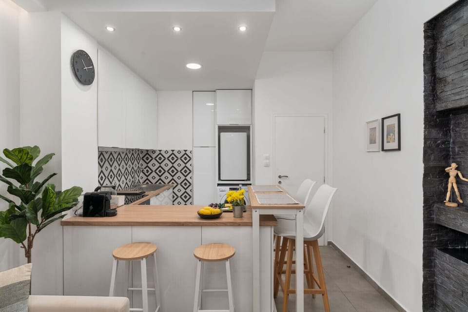 Open kitchen and dining area with modern design, bar seating, and elegant lighting.