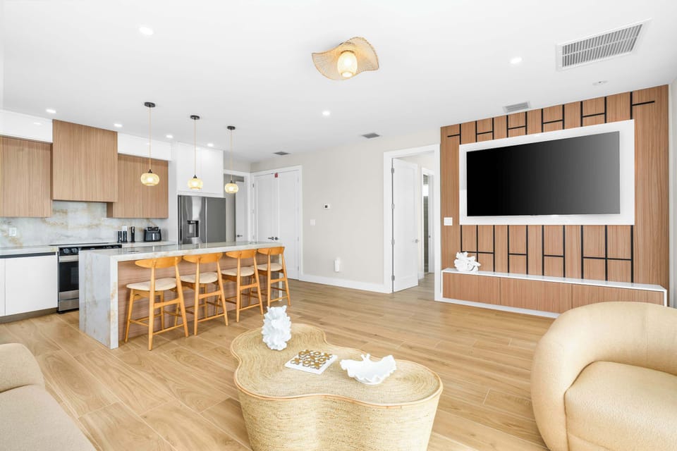 Spacious living area with large smart TV and seamless flow to the kitchen, made for movie nights and quality time with loved ones.
