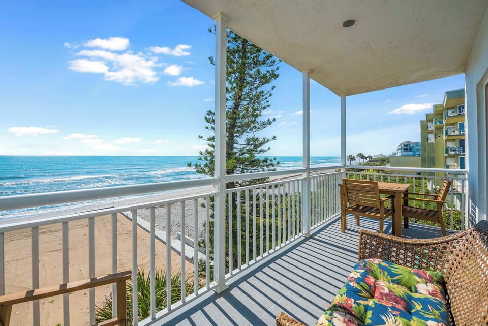 Relax on the balcony with ocean views and comfortable seating.