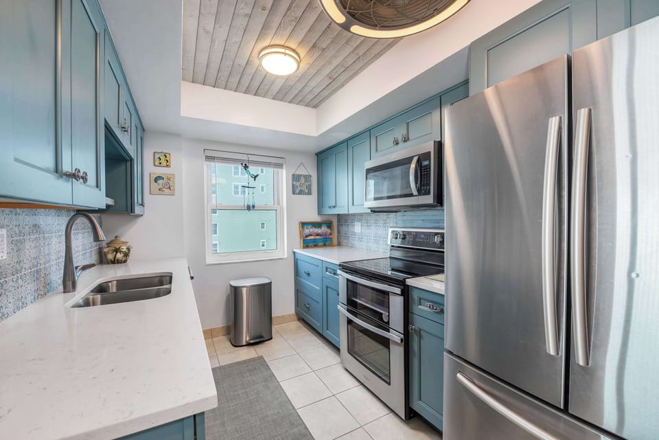 Modern kitchen with blue cabinetry and stainless steel appliances