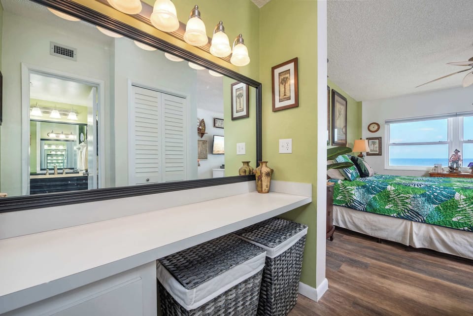 Cozy bedroom with ocean views and a bright vanity area.