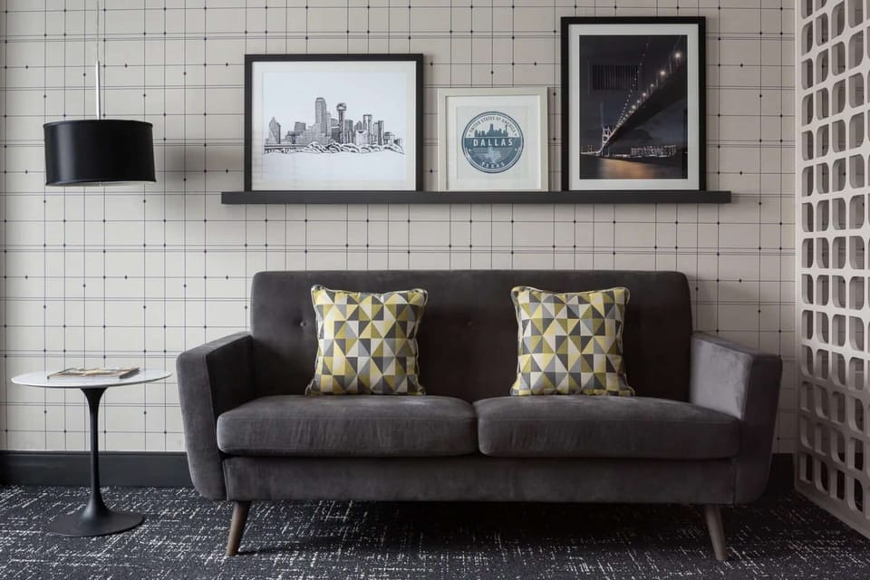 Comfy gray couch with bold pillows and framed wall art
