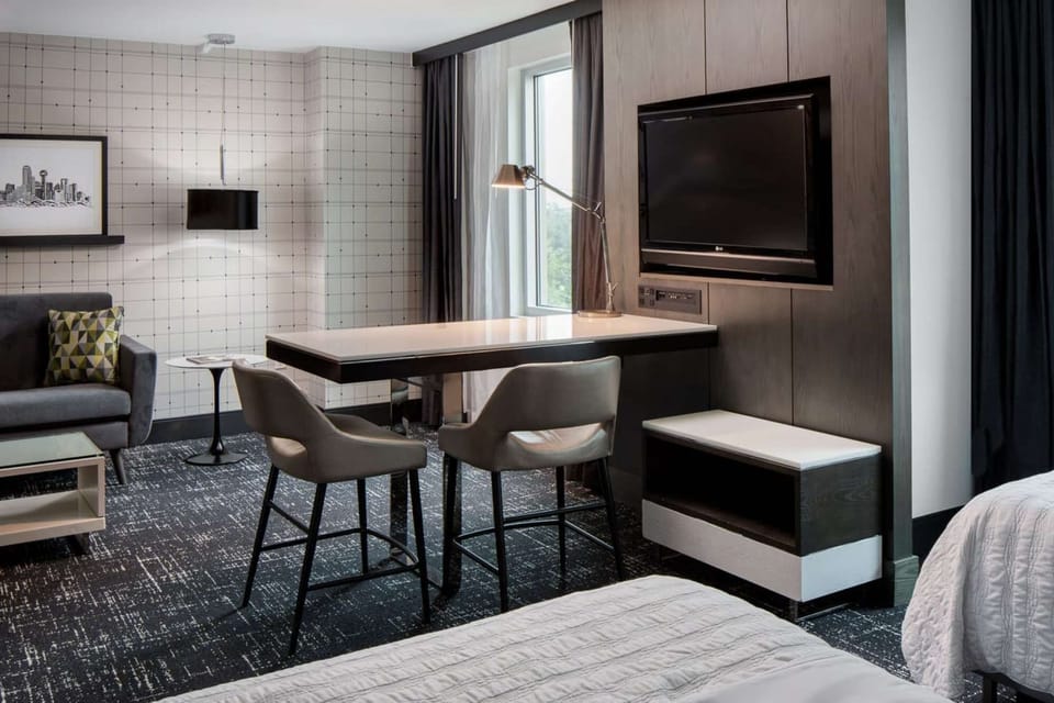 Cozy space with desk, chairs, TV, and window-side couch
