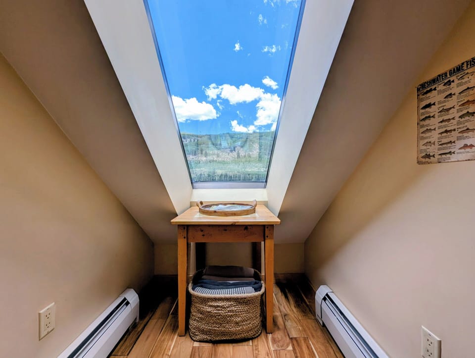 A dramatic skylight frames mountain and sky views above this cozy nook, where natural light floods in to brighten your mornings and peaceful evenings await.