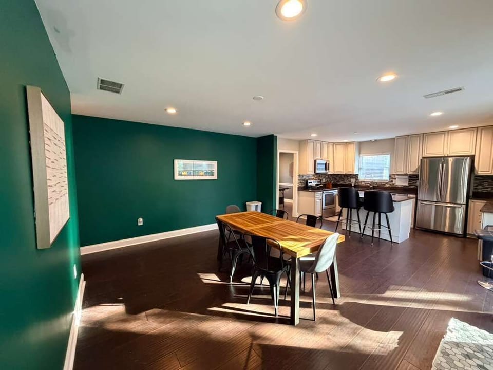 Spacious dining area with a sturdy wooden table and cushioned chairs, offering plenty of room for shared meals and evening board games.