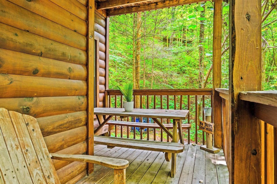 Serene outdoor deck with seating and a picnic table amidst nature!