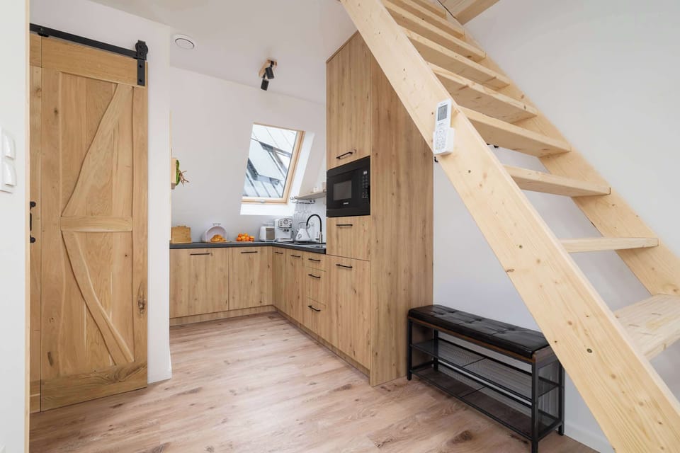 A compact kitchen area with natural wood cabinets and a skylight. The layout feels efficient and well-lit.