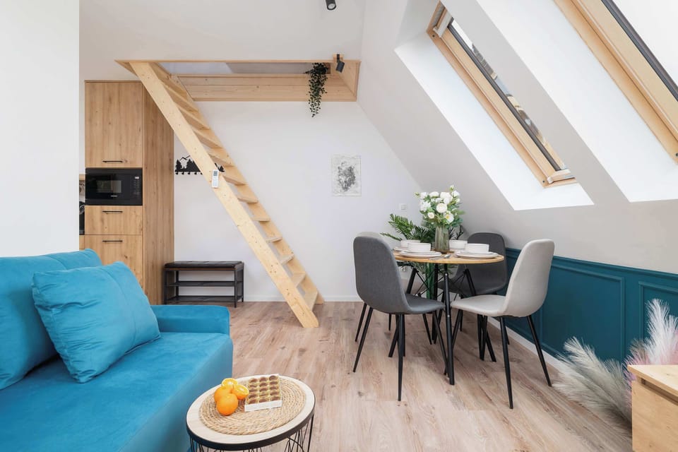 A bright corner with blue furniture, a small table, and natural light coming through skylights. The atmosphere is cheerful and peaceful.