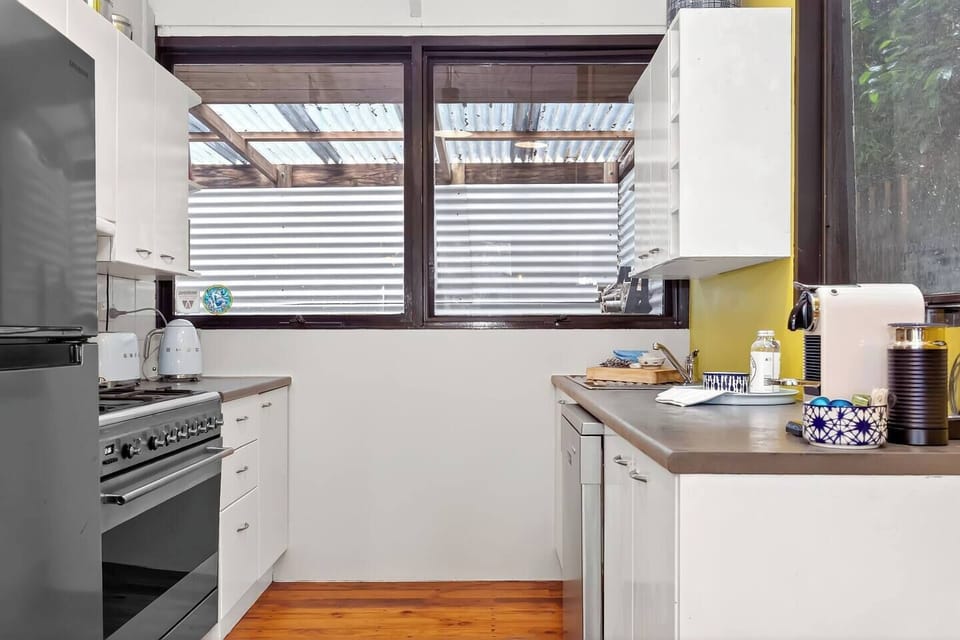 Prepare simple meals in the fully equipped kitchen featuring a gas stove, espresso machine, microwave, fridge, and modern appliances for easy, home-style cooking.