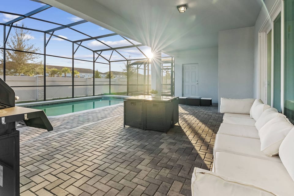 Immerse yourself in a bright space with sunlit paver flooring. Unwind in modern seating and take refreshing dips in the sparkling pool, creating unforgettable evenings filled with laughter and warmth in this welcoming atmosphere.