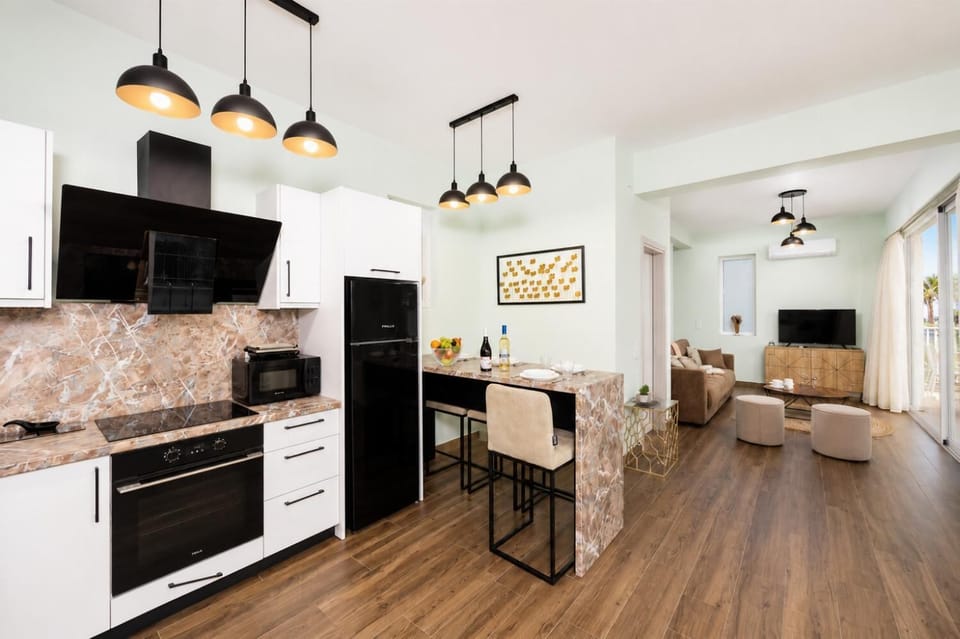Open-plan living room with sofa, dining area, kitchen, A/C, WiFi internet, and satellite TV