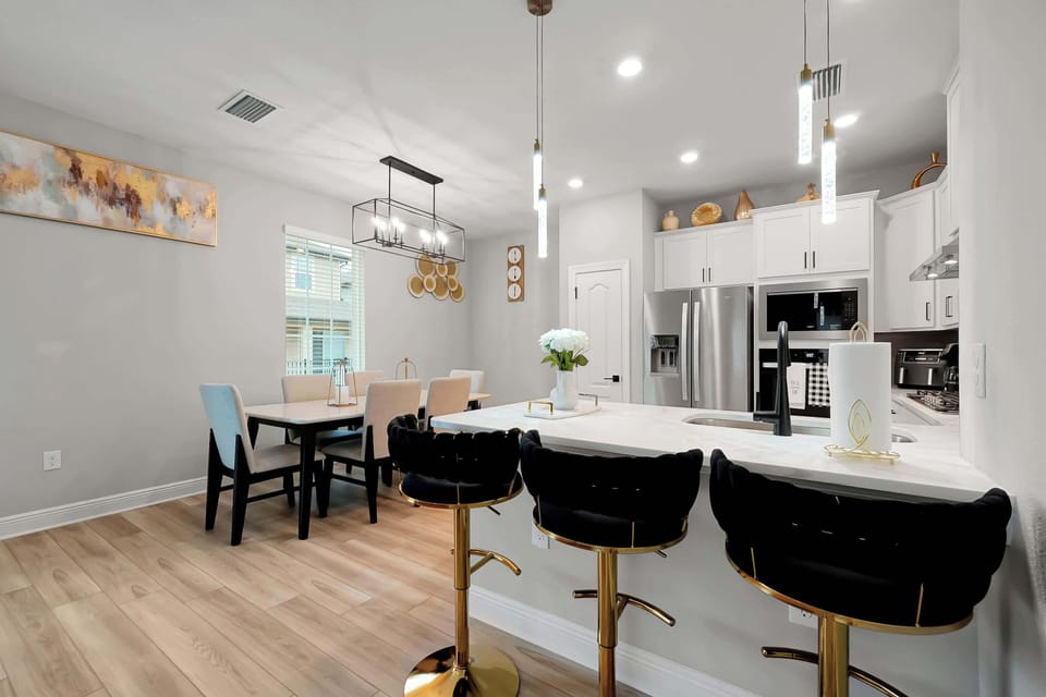 Dine in style! 🍽️ Prepare delicious meals in this fully-equipped, modern kitchen with a spacious island and lovely dining area.