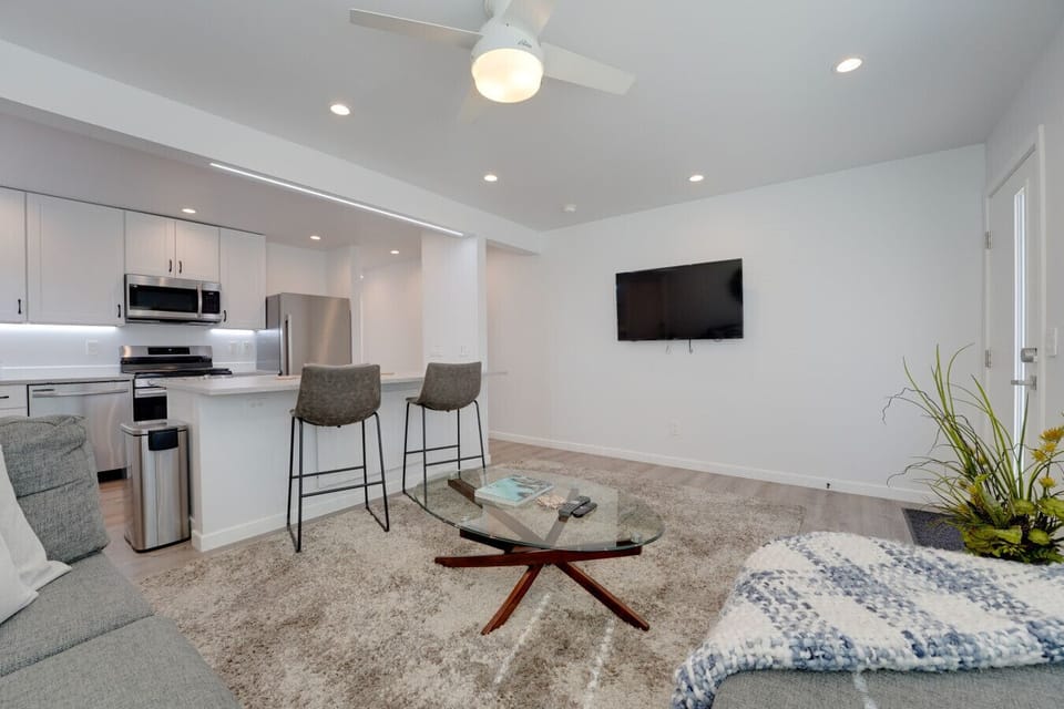Relax in this light-filled open living space featuring a plush sectional, stylish décor, and a modern kitchen just steps away.