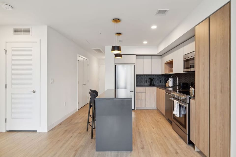 Cook together in a sleek, sunlit kitchen with island seating.