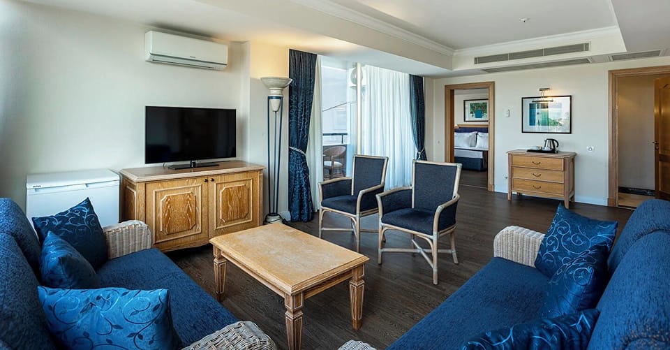 Comfort King Suite Pool View | Living area | 55-inch LCD TV with satellite channels