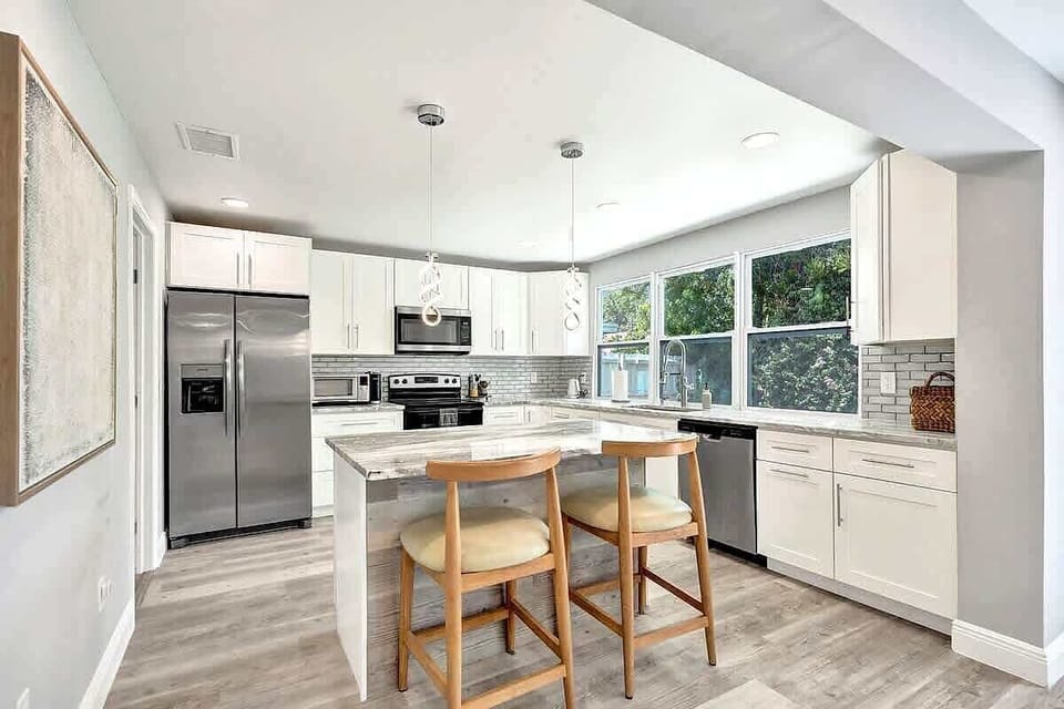 White kitchen with island seating and pendant lights