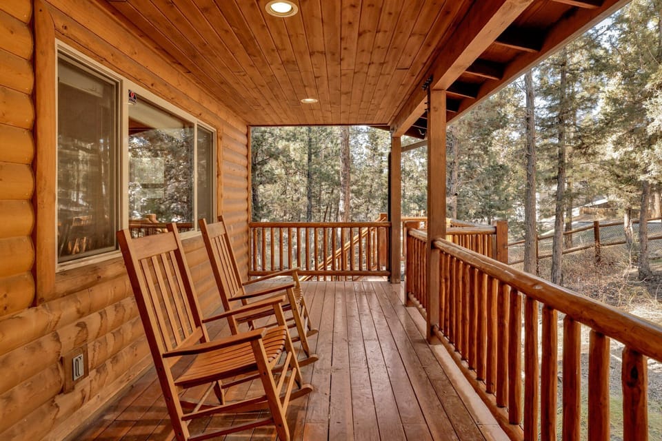 Covered porch with classic rocking chairs, offering a cozy place to relax year-round while enjoying forest views and fresh mountain air.