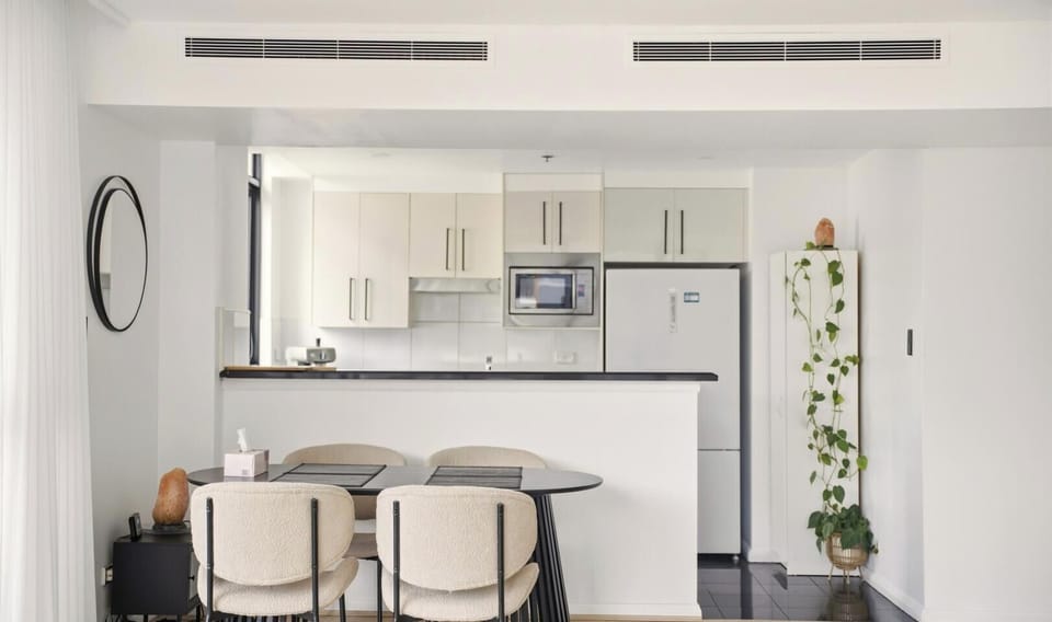 A bright, open-plan kitchen and dining space with light wood cabinetry.
